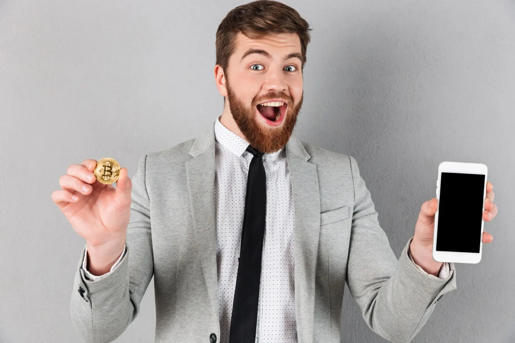Glad mann med bitcoin og mobiltelefon